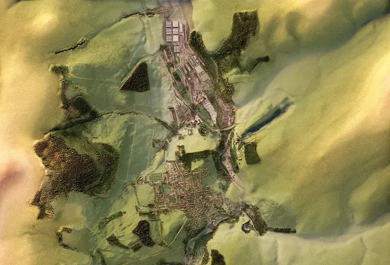 A detailed 3D shaded relief topographic map of Dufftown, Scotland, showing the town's layout nestled within a rolling green valley. Dense clusters of dark green trees and patches of agricultural fields surround the residential grid, while large industrial distillery complexes with grey rooftops are visible on the northern outskirts of the settlement